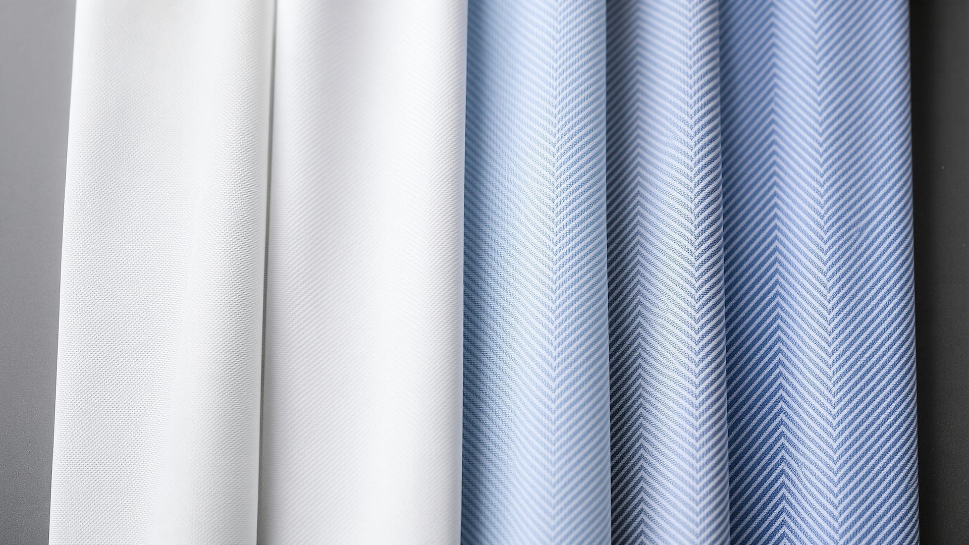 Four squares of cotton shirting showing poplin, oxford, twill and herringbone weaves side by side